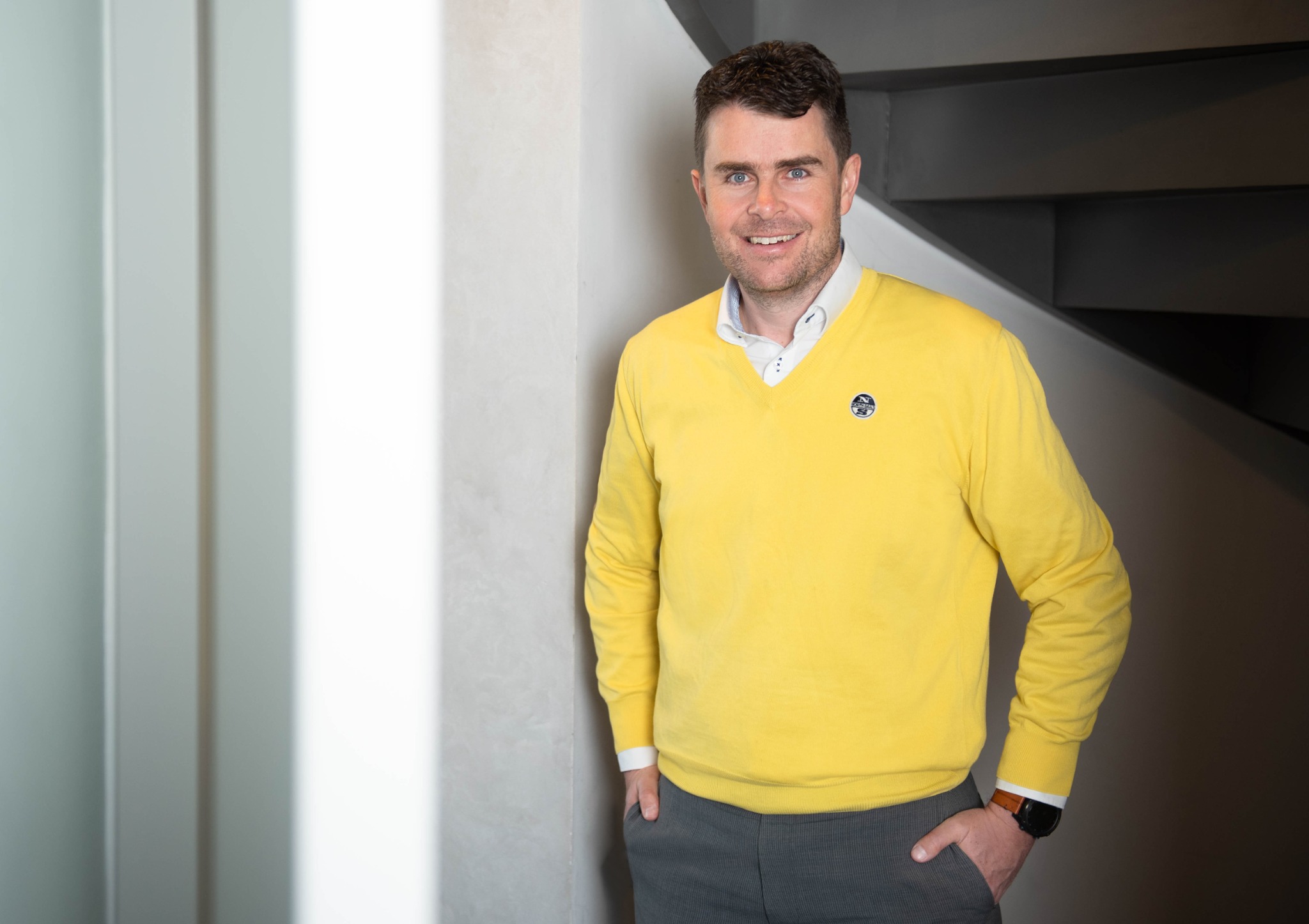 Phillip Truppe im gelben Pullover vor heller Wand